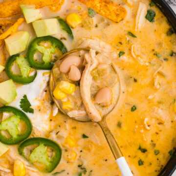 overhead close up view of white chicken chili on spoon