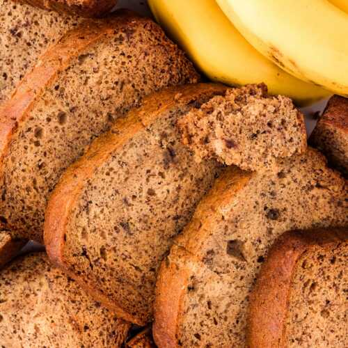 overhead view of sliced banana bread with fresh bananas