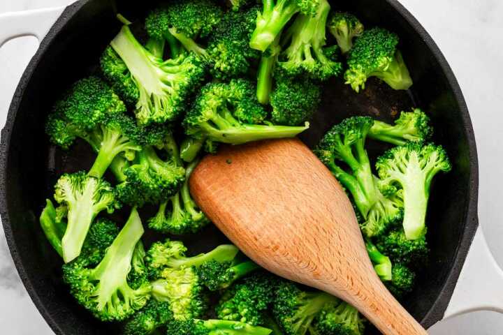 overhead view of wooden spoon in pan with broccoli