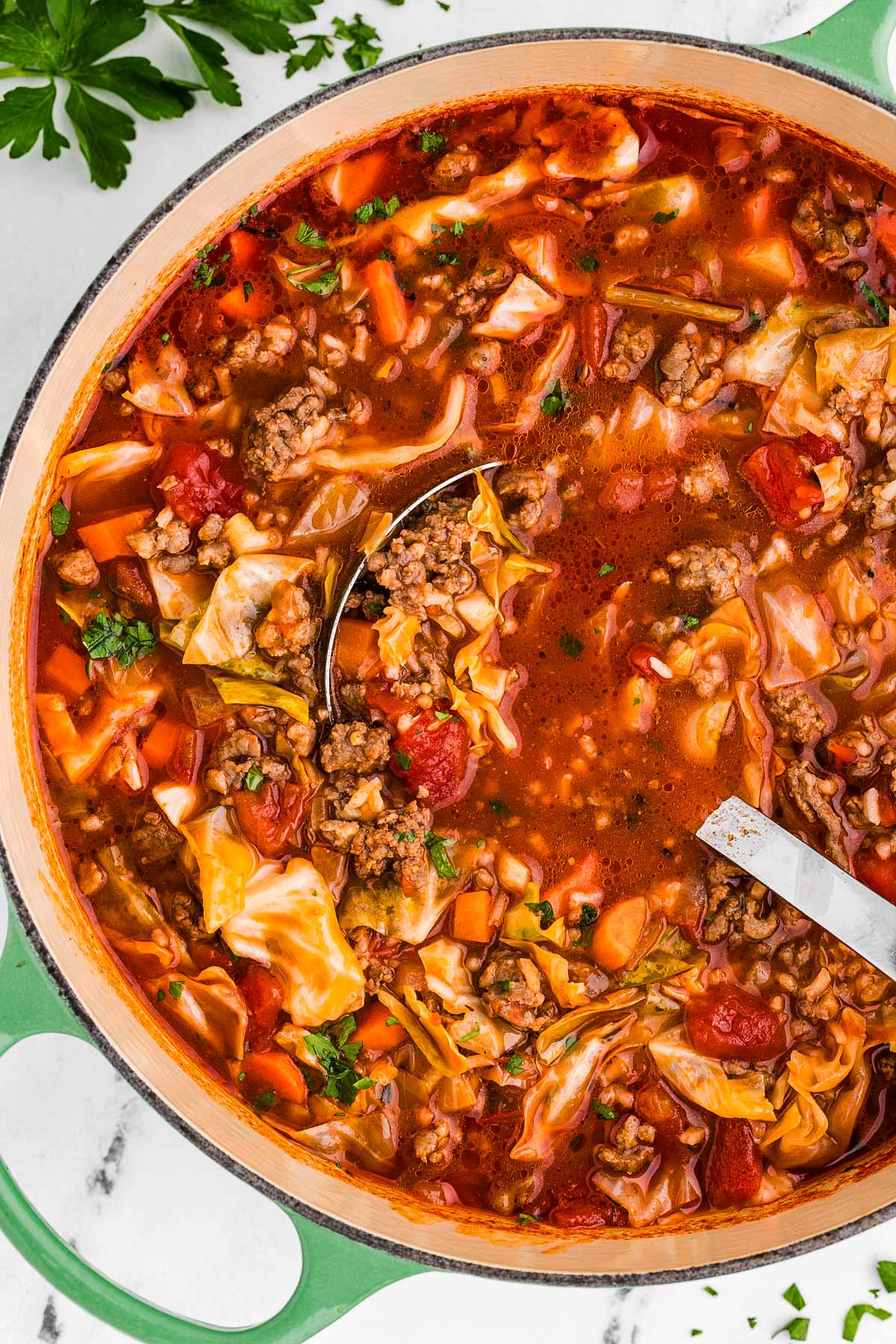 overhead view of pot filled with cabbage roll soup with ladle