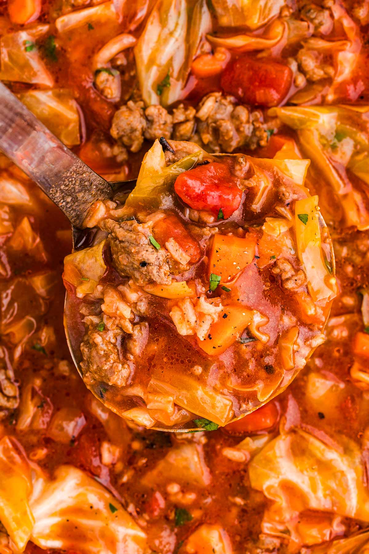 overhead close up view of cabbage roll soup on ladle