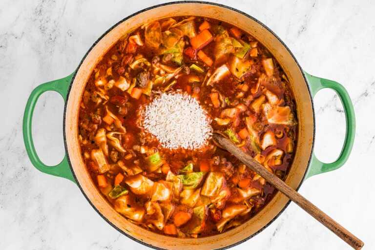 overhead view of soup pot filled with uncooked cabbage roll soup and uncooked rice