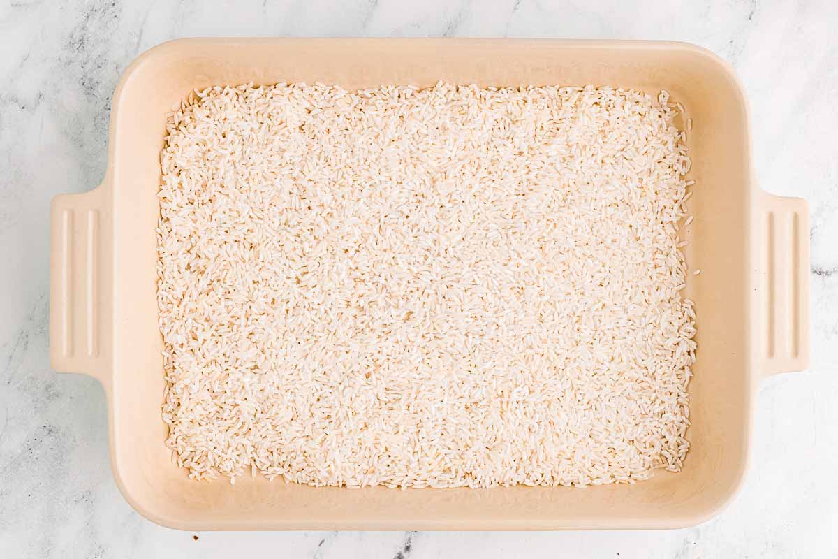 overhead view of uncooked white rice in casserole dish