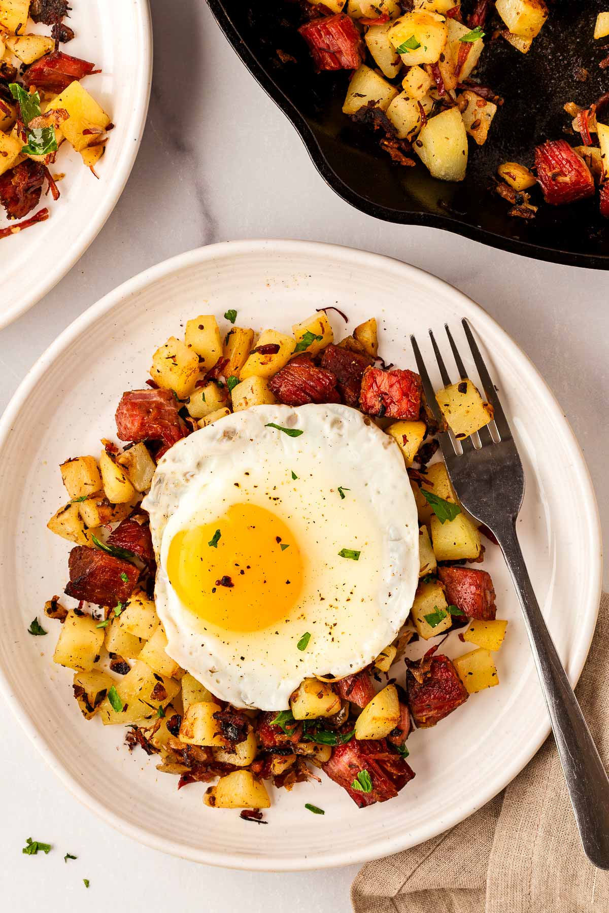 overhead view of corned beef hash on plate topped with fried egg