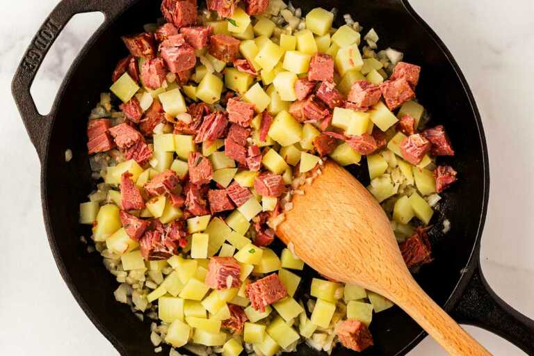 overhead view of corned beef and cubed potatoes in skillet