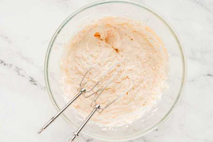 overhead view of cream cheese, sour cream and thousand island dressing in glass bowl