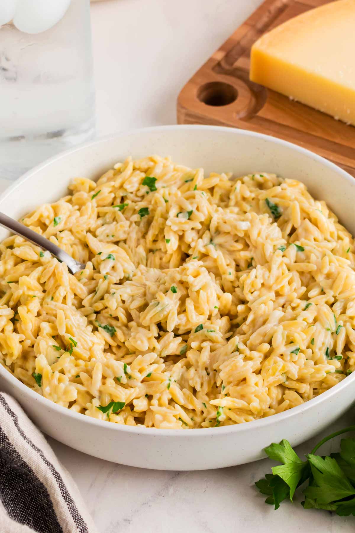 45 degree view of creamy orzo pasta in white bowl