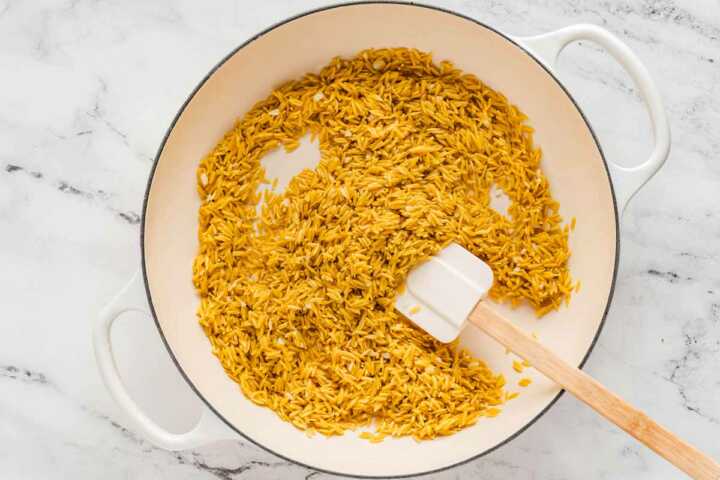 overhead view of orzo being toasted in pan