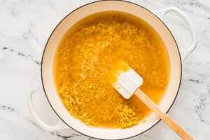 overhead view of orzo and broth in pan