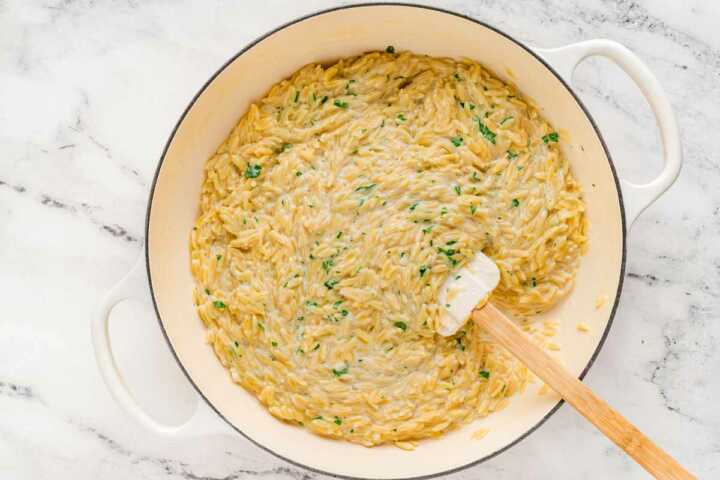 overhead view of creamy garlic parmesan orzo in pan right after cooking