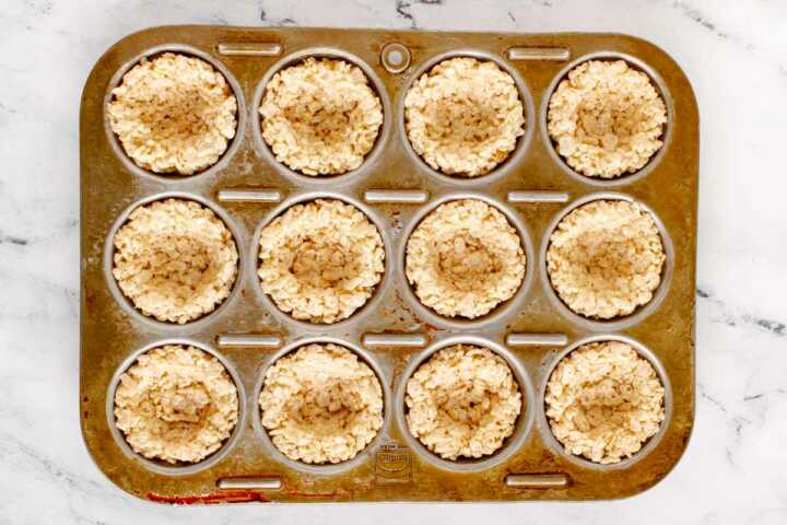 overhead view of muffin pan filled with Rice Krispie "easter nest" bases