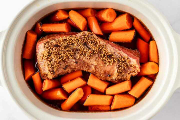 overhead view of corned beef and carrots in slow cooker