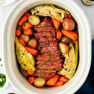 overhead view of corned beef, cabbage and vegetables in slow cooker insert