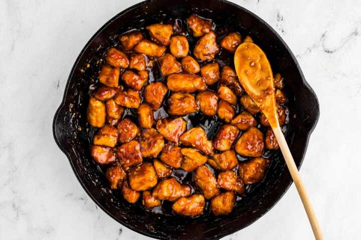 overhead view of teriyaki chicken in skillet with spoon