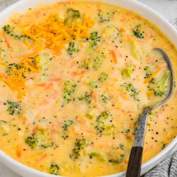 Bowl of creamy broccoli cheddar soup with shredded cheese on top