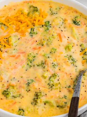 Bowl of creamy broccoli cheddar soup with shredded cheese on top