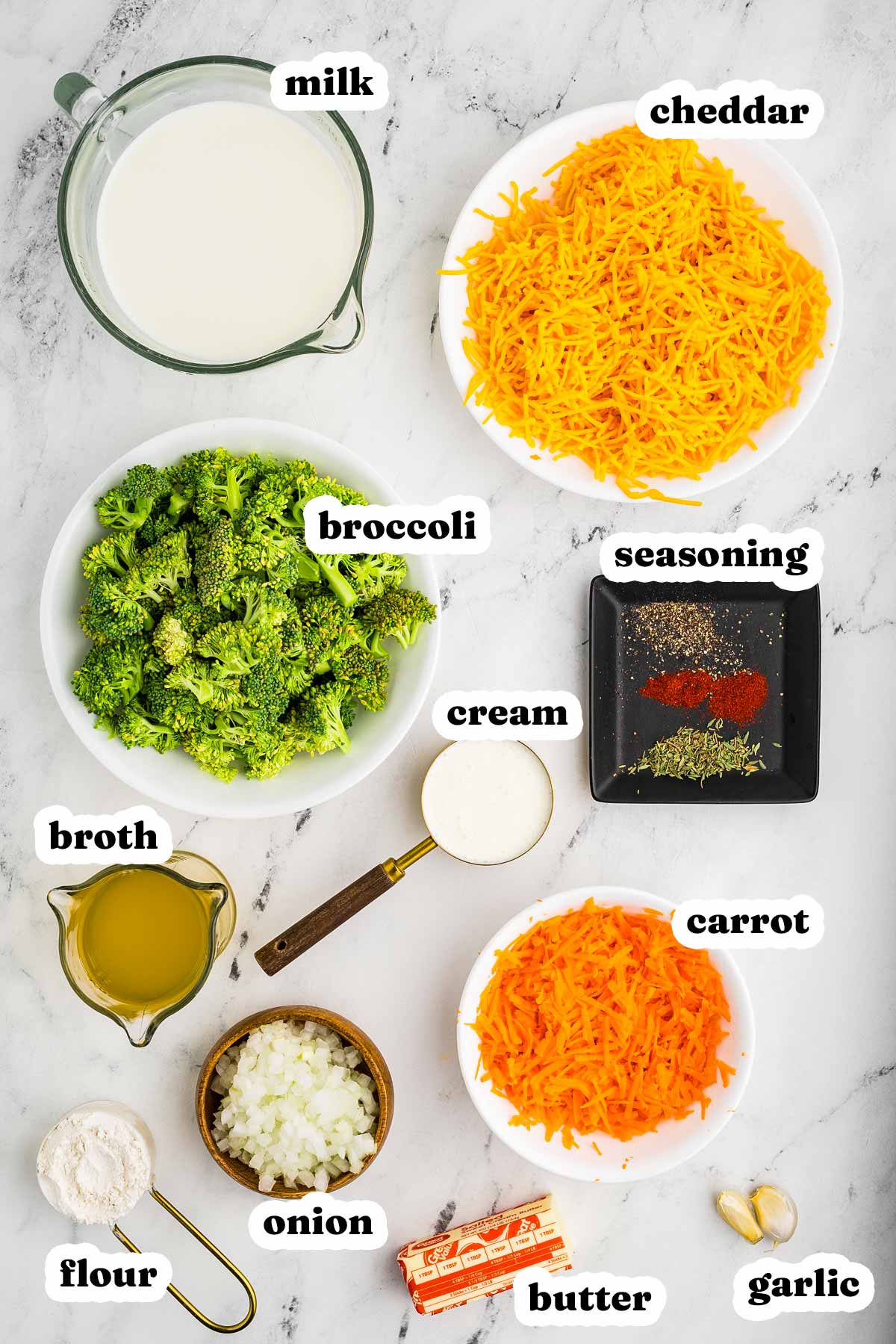 Ingredients for broccoli cheddar soup including broccoli, cheddar, onion, carrot, and cream