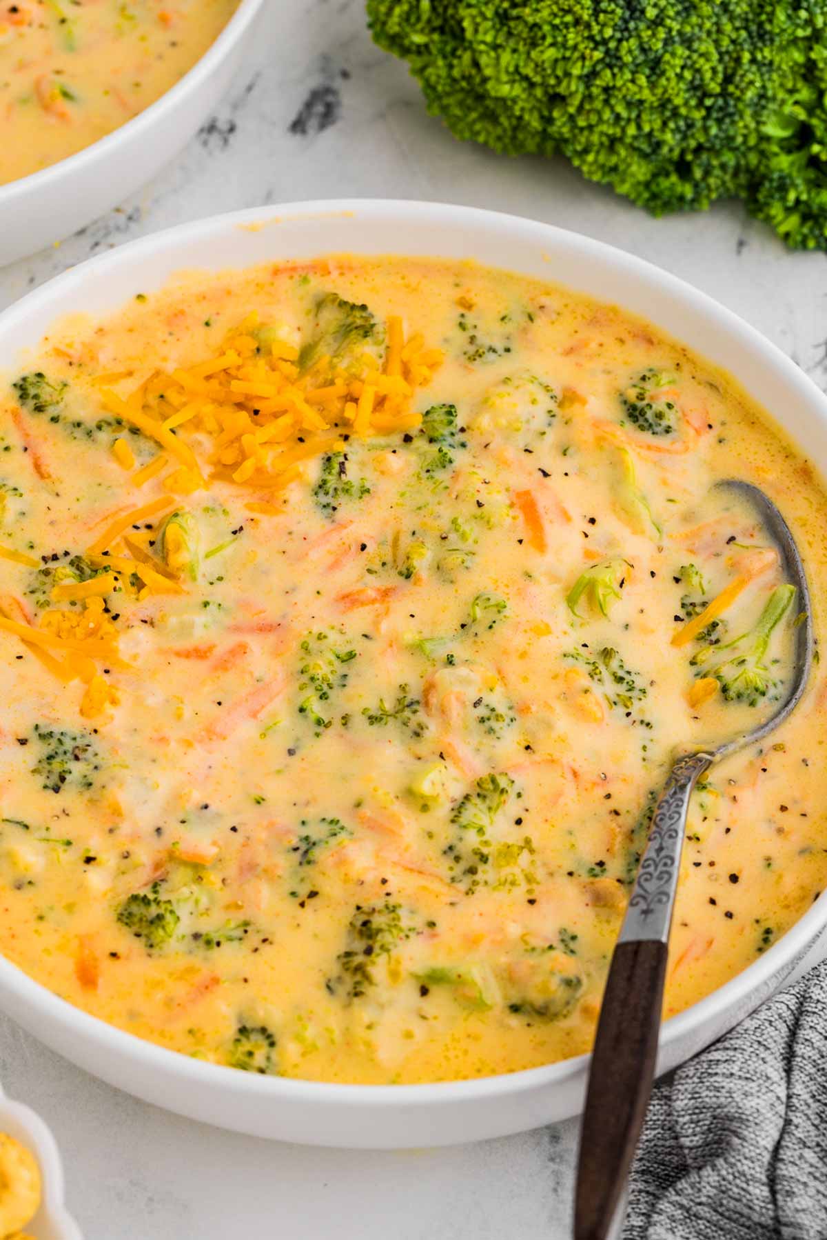 Bowl of creamy broccoli cheddar soup with shredded cheese on top