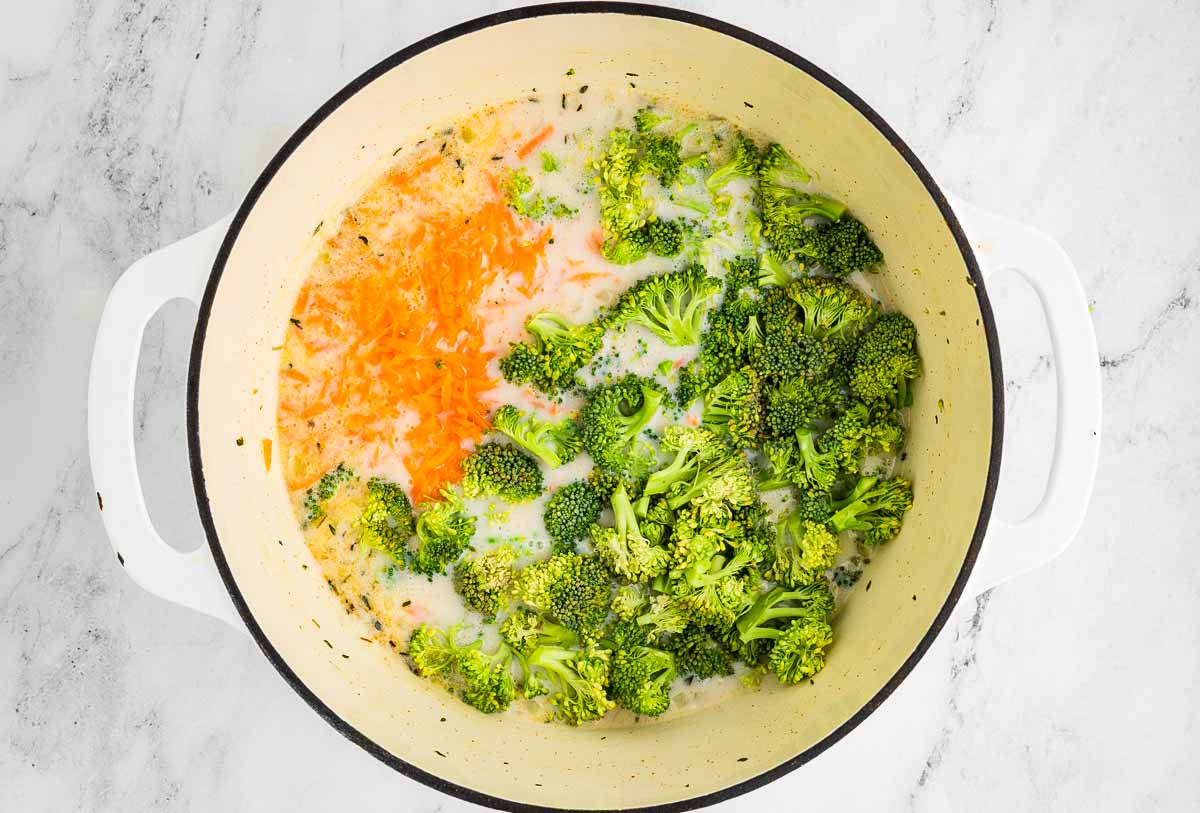 Chopped broccoli and shredded carrot simmering in soup