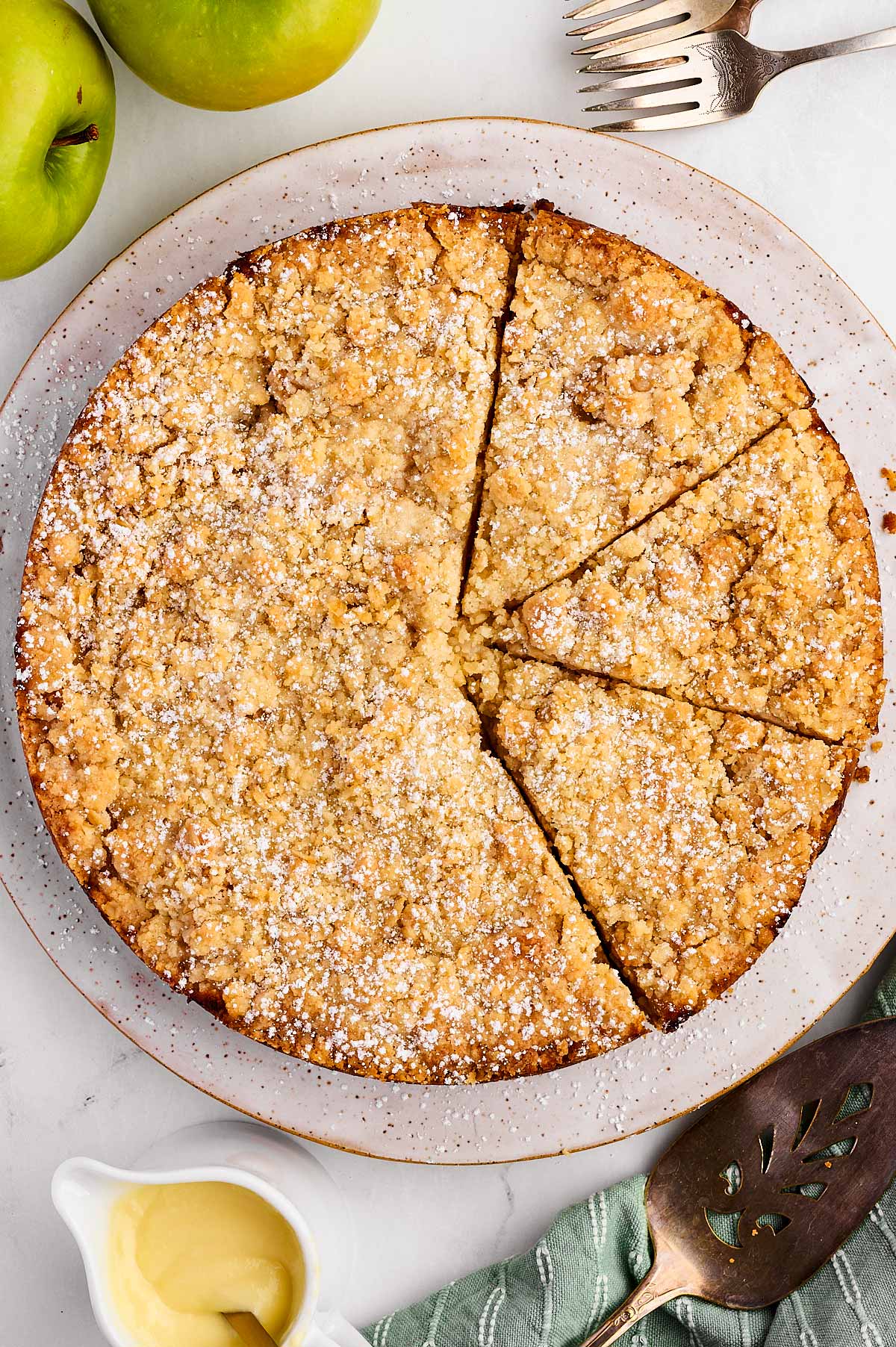 Overhead view of cinnamon-spiced Irish apple cake with streusel and sliced Granny Smith apples.