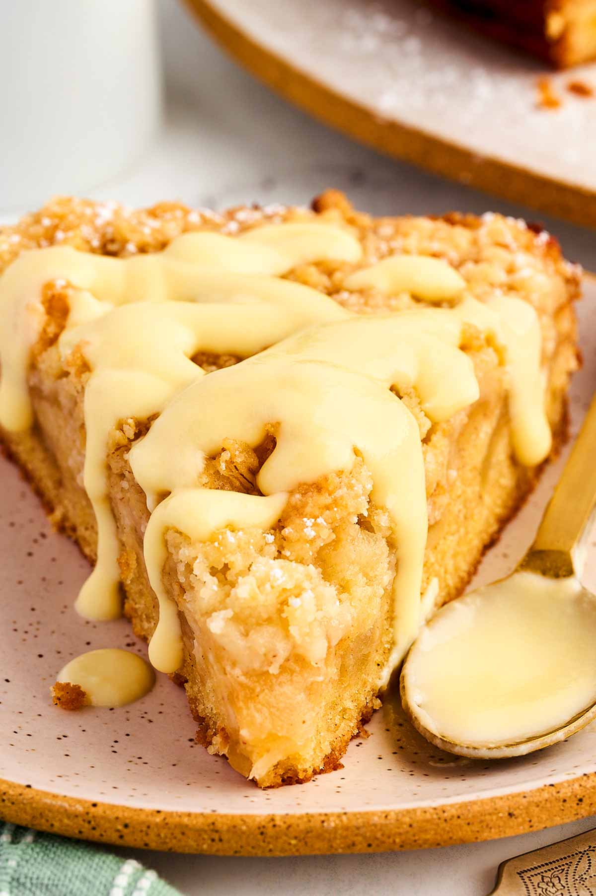 frontal view of Irish apple cake slice topped with vanilla sauce