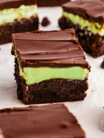 Fudgy mint brownies with green peppermint frosting and glossy chocolate ganache, sliced into squares