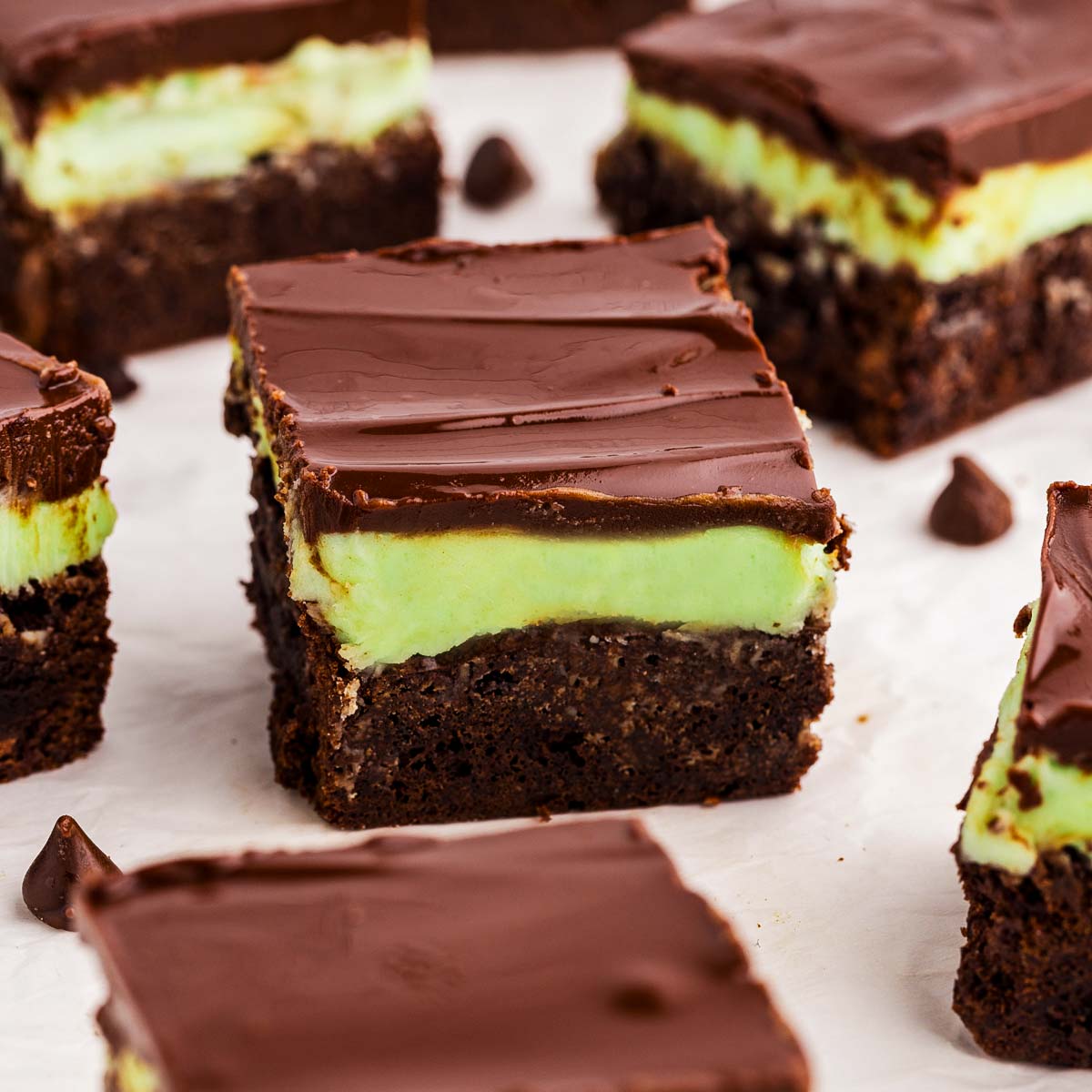 Fudgy mint brownies with green peppermint frosting and glossy chocolate ganache, sliced into squares