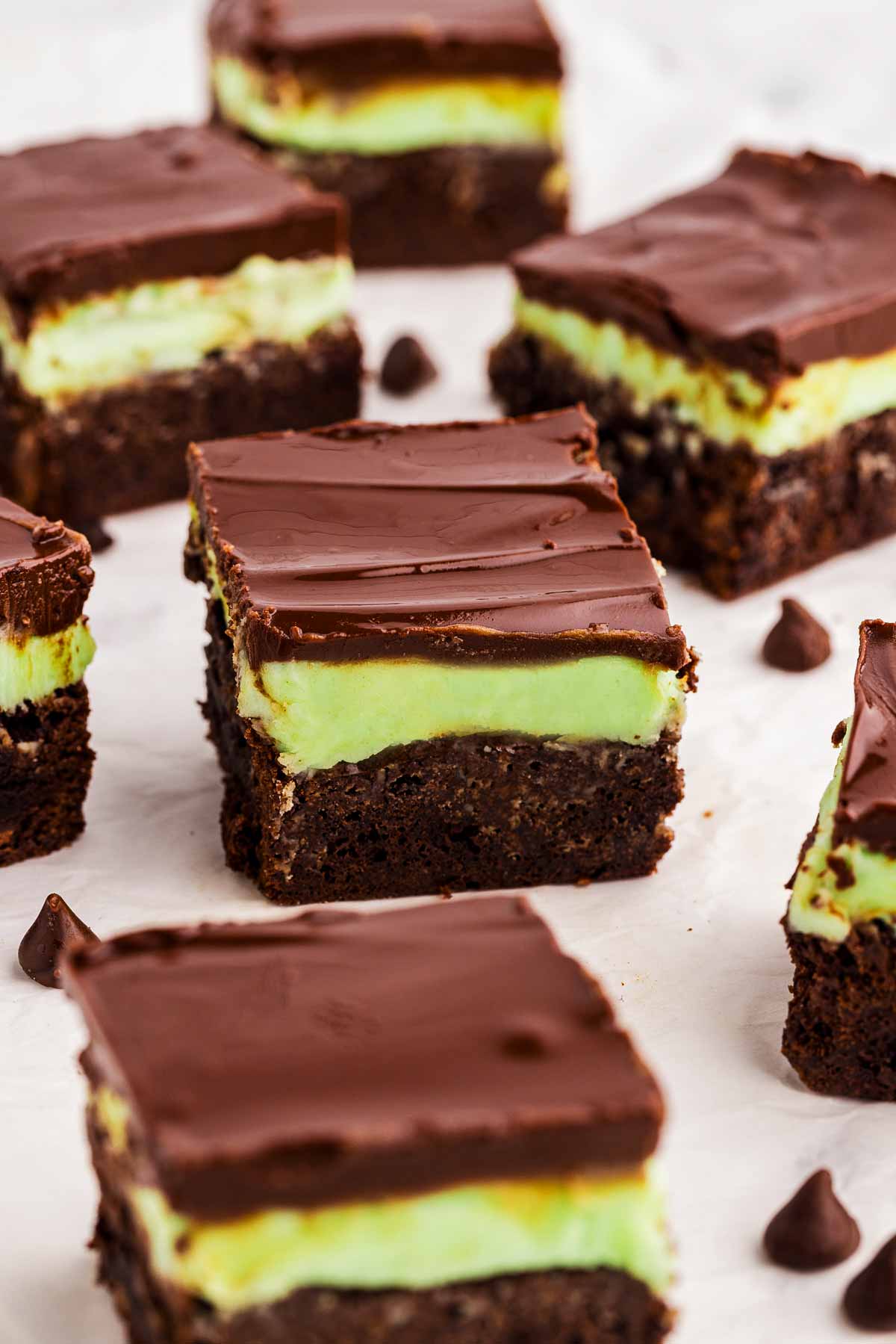 Fudgy mint brownies with green peppermint frosting and glossy chocolate ganache, sliced into squares