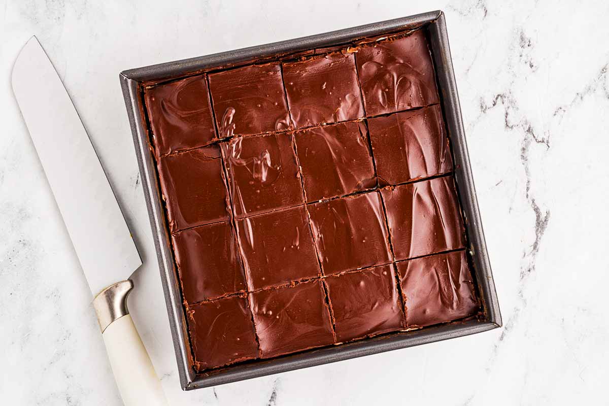 Mint brownies sliced with a sharp knife in pan